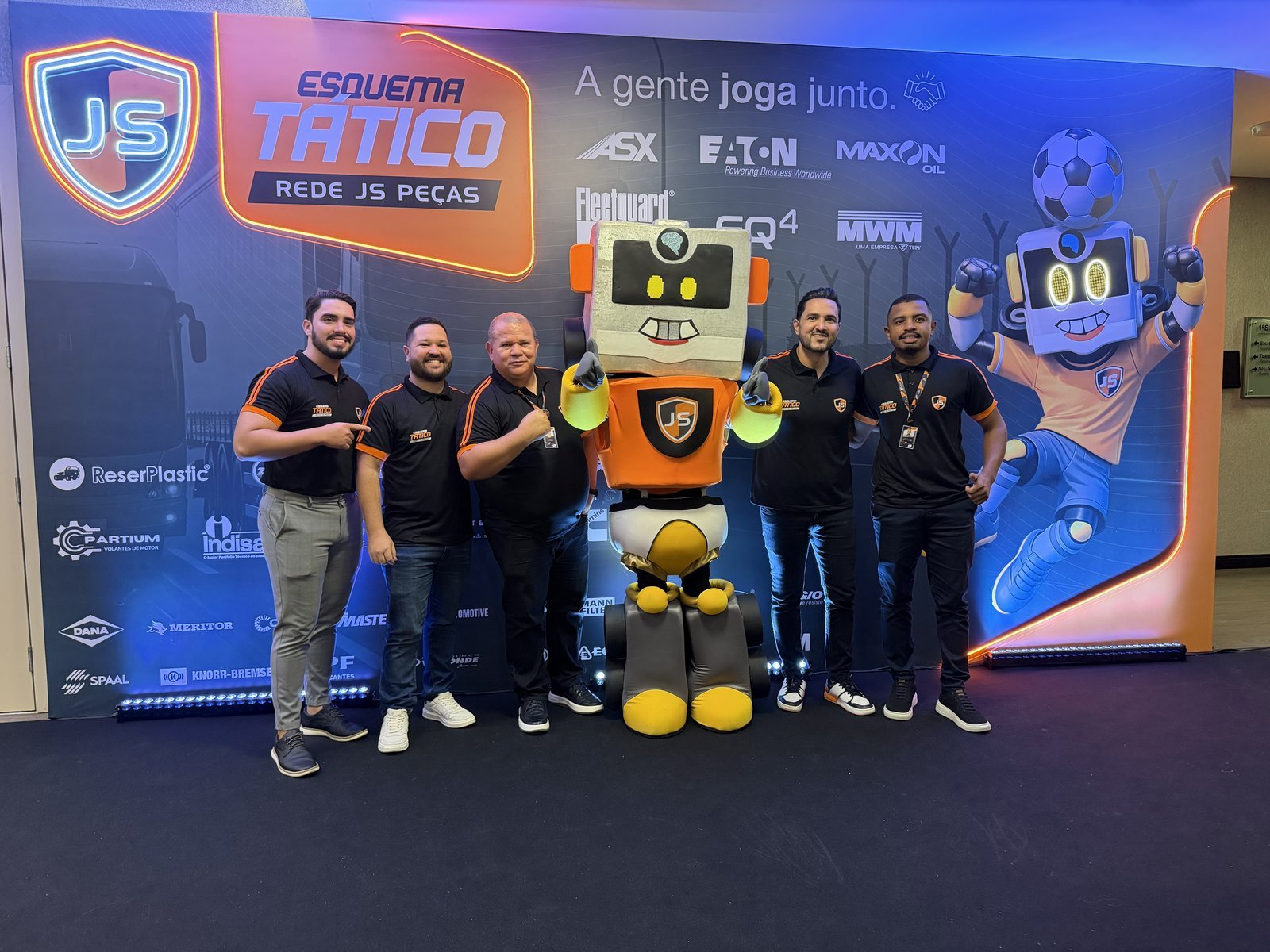 Equipe JS Peças com mascote robô em tamanho real