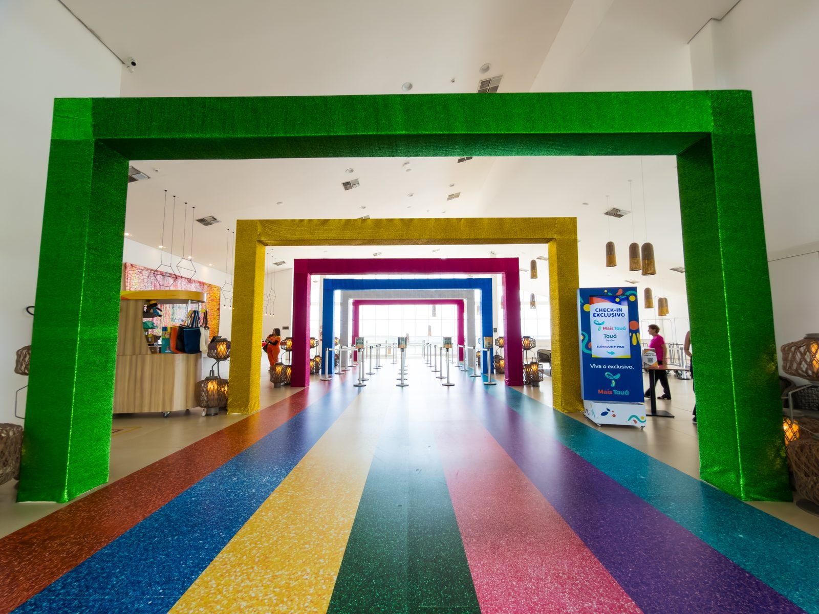 Sequência de pórticos coloridos na recepção — verde, amarelo, rosa e azul